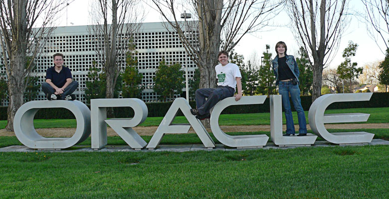 Tim, Daniel and Zhanna standing on the Oracle sign