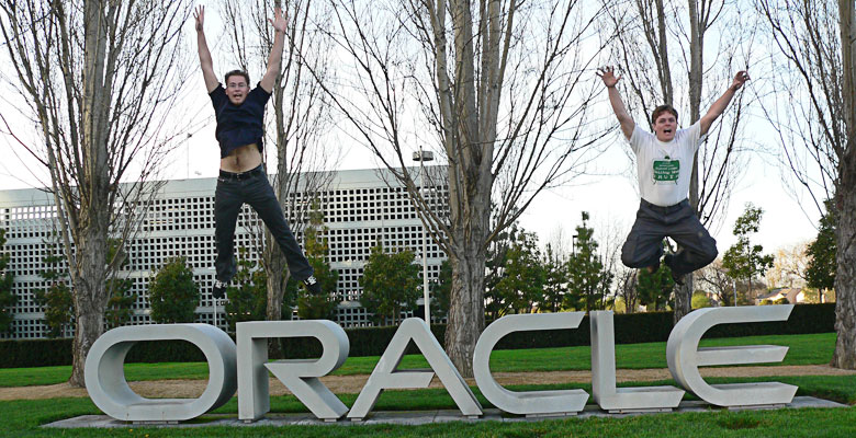 Tim and Daniel jumping of the Oracle sign