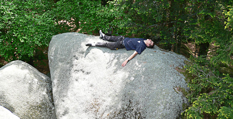 Alex is playing dead on huge rock.