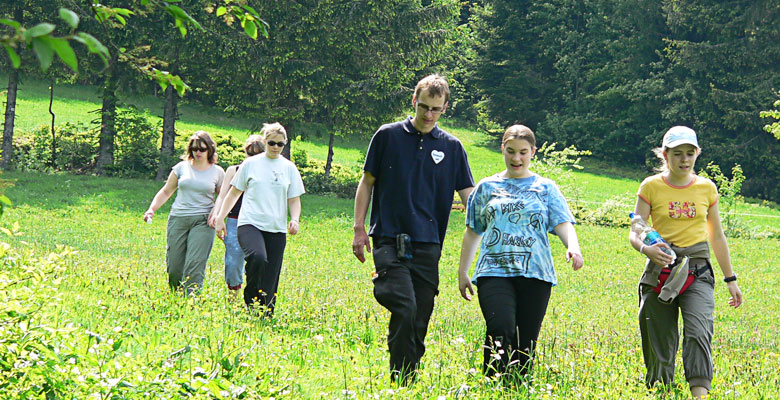 A group takes a short cut through a field.